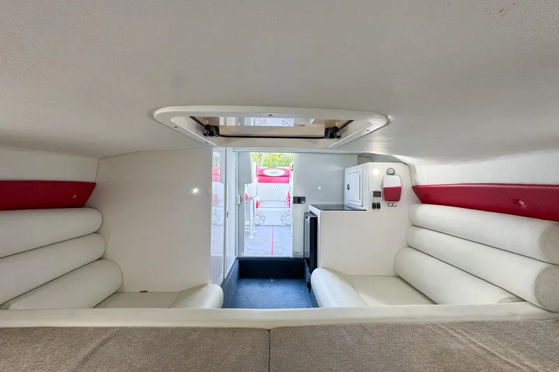  Yacht Photos Pics 2022 Velocity 290sc boat interior with white and red seating, compact kitchenette.