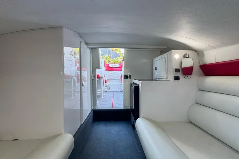  Yacht Photos Pics Interior of 2022 Velocity 290sc boat, featuring white seating and compact cabin amenities.