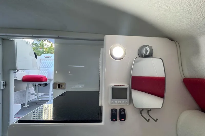  Yacht Photos Pics Interior of 2022 Velocity 290sc boat with control panel, mirror, and seating.