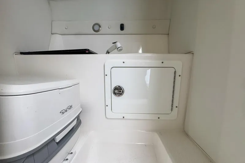  Yacht Photos Pics 2022 Velocity 290sc boat interior with compact toilet and storage compartment.