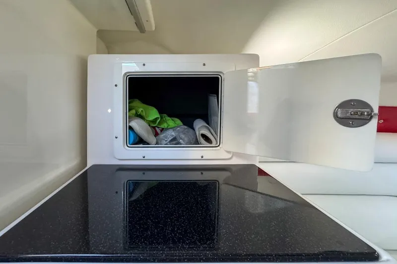  Yacht Photos Pics Open storage compartment in 2022 Velocity 290sc boat interior with items inside.