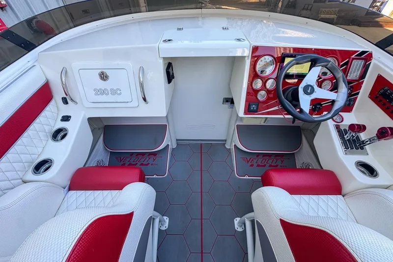  Yacht Photos Pics 2022 Velocity 290sc boat interior with red and white seating, modern dashboard, and steering wheel.
