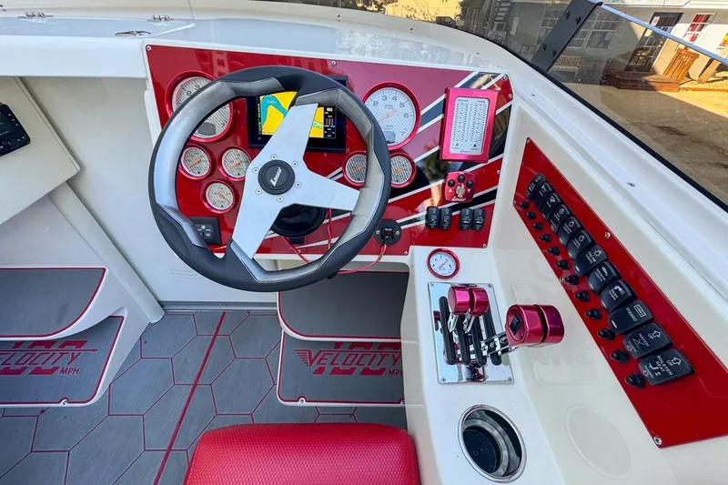  Yacht Photos Pics Cockpit of 2022 Velocity 290sc boat with red accents and modern controls.
