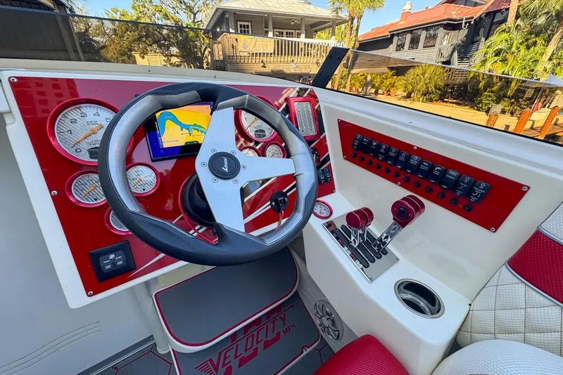  Yacht Photos Pics 2022 Velocity 290sc boat dashboard with red accents and navigation display.
