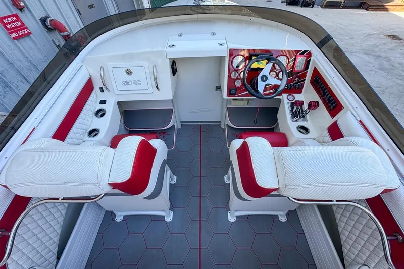  Yacht Photos Pics 2022 Velocity 290sc boat interior with red and white seating, modern dashboard, and steering wheel.