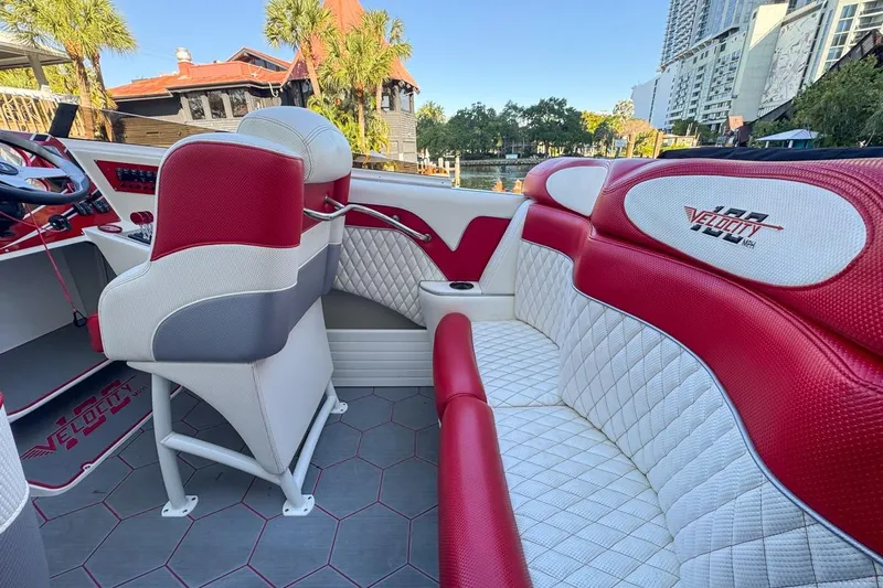  Yacht Photos Pics Interior of 2022 Velocity 290sc boat with red and white seating, cityscape background.