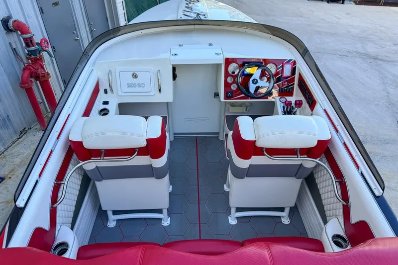  Yacht Photos Pics 2022 Velocity 290sc boat interior with red and white seating, modern dashboard, and hexagonal flooring.