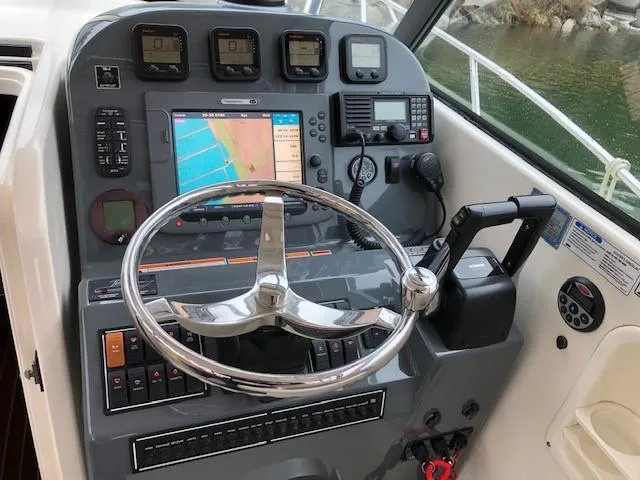 Good Fun Yacht Photos Pics Helm of 2006 Pursuit 3370 Offshore boat with navigation equipment and steering wheel.