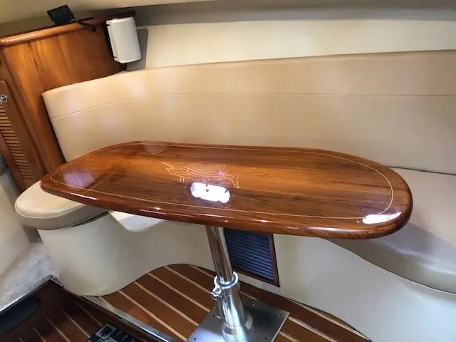 Good Fun Yacht Photos Pics 2006 Pursuit 3370 Offshore cabin with polished wooden table and beige seating.