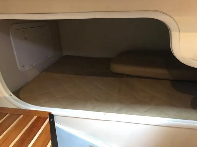 Good Fun Yacht Photos Pics 2006 Pursuit 3370 Offshore cabin interior with cozy sleeping area and wooden accents.