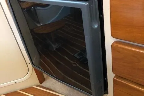 Good Fun Yacht Photos Pics 2006 Pursuit 3370 Offshore interior with wood cabinetry and compact refrigerator.