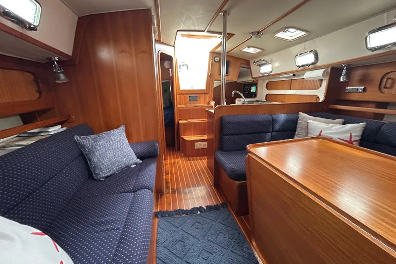 Harriet Tubman Yacht Photos Pics Interior of a 2002 Caliber 40 sailboat with wood finish and blue upholstery.