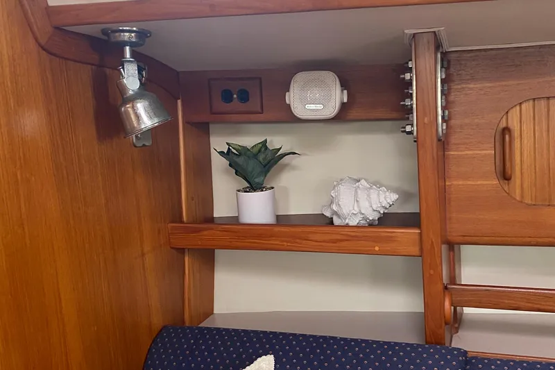 Harriet Tubman Yacht Photos Pics Wooden interior of 2002 Caliber 40 yacht with shelf, plant, and shell decor.