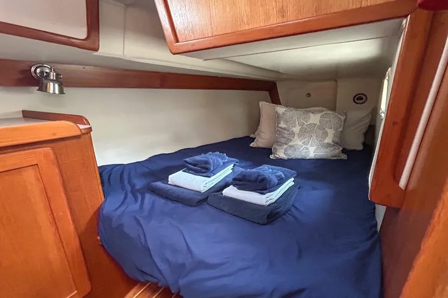 Cozy cabin interior of 2002 Caliber 40 sailboat with neatly arranged bedding.