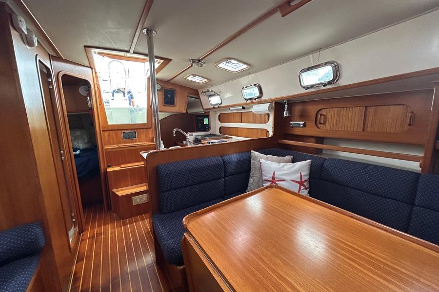 Interior of 2002 Caliber 40 sailboat with wood finish and cozy seating area.