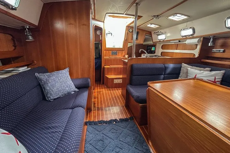 Harriet Tubman Yacht Photos Pics Interior of 2002 Caliber 40 sailboat with wooden furnishings and blue seating.