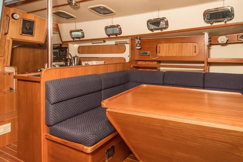 Harriet Tubman Yacht Photos Pics Interior of a 2002 Caliber 40 sailboat with wooden furnishings and blue seating.