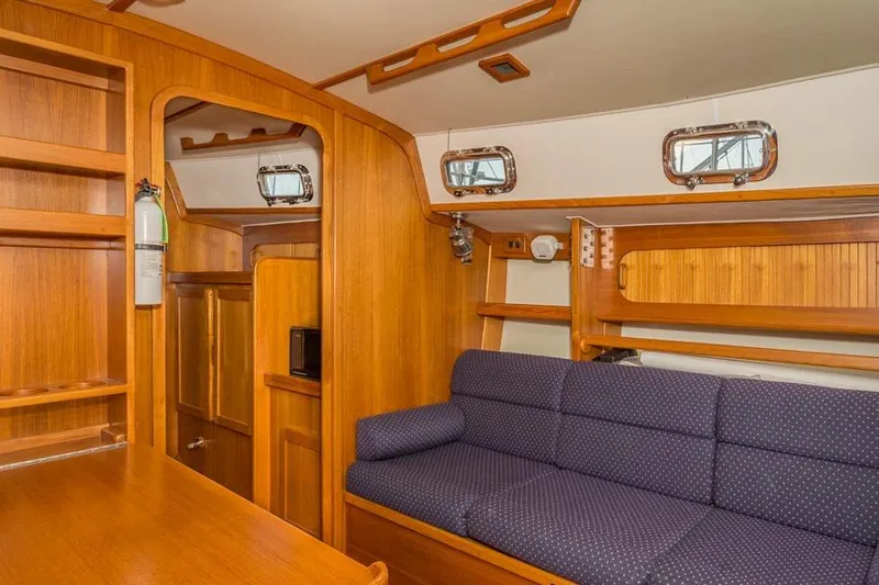 Harriet Tubman Yacht Photos Pics Interior of 2002 Caliber 40 sailboat with wooden cabinetry and blue upholstered seating.