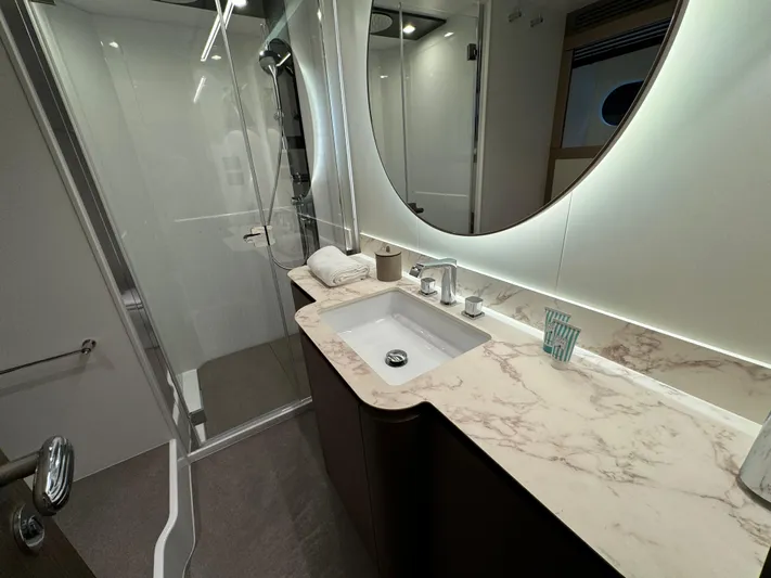  Yacht Photos Pics Luxurious bathroom in 2025 Azimut Magellano 66 yacht with marble countertop and modern shower.