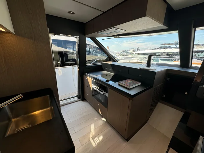  Yacht Photos Pics Modern kitchen interior of 2025 Azimut Magellano 66 yacht, featuring sleek design and marina view.