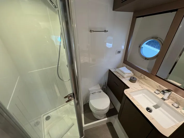  Yacht Photos Pics Luxurious bathroom in 2025 Azimut Magellano 66 yacht with shower, toilet, and sink.