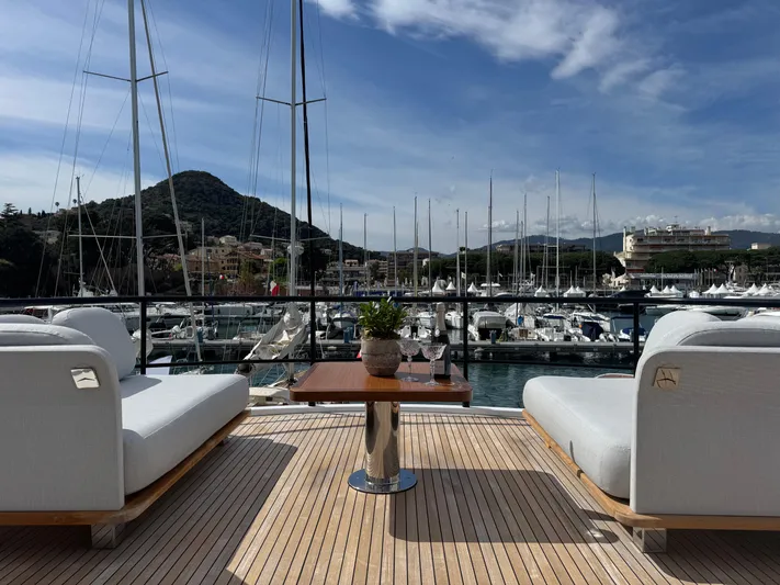  Yacht Photos Pics Luxurious Azimut Magellano 66 yacht deck with elegant seating, overlooking marina and mountains, 2025 model.