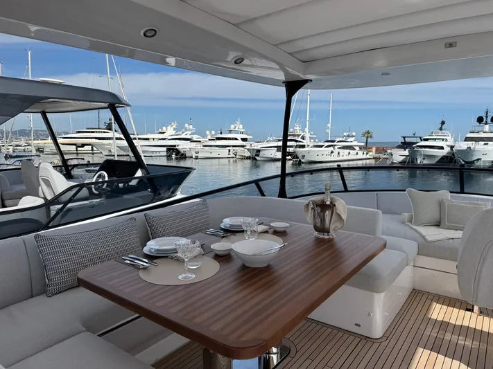  Yacht Photos Pics Luxurious 2025 Azimut Magellano 66 yacht with elegant dining area, docked at marina.
