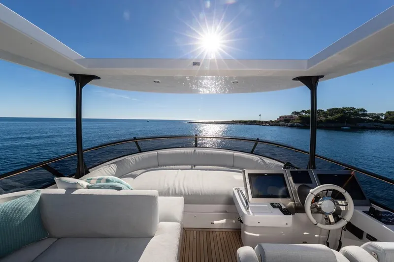  Yacht Photos Pics Luxurious 2025 Azimut Magellano 66 yacht with sunlit deck and ocean view.