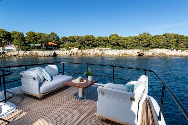  Yacht Photos Pics Luxurious 2025 Azimut Magellano 66 yacht deck with elegant seating and scenic coastal view.
