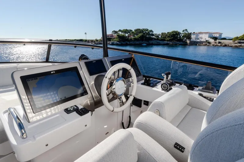  Yacht Photos Pics 2025 Azimut Magellano 66 yacht helm with modern navigation systems, overlooking serene coastal waters.