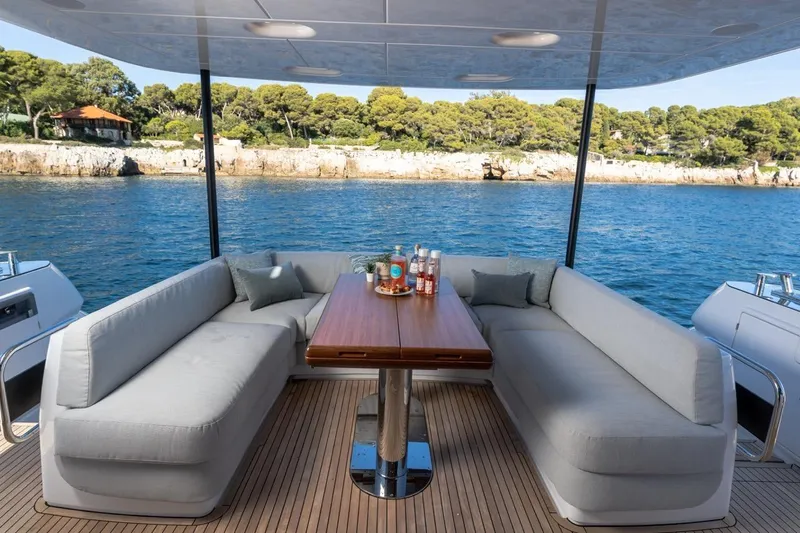  Yacht Photos Pics Luxury seating area on 2025 Azimut Magellano 66 yacht, overlooking serene coastal waters.