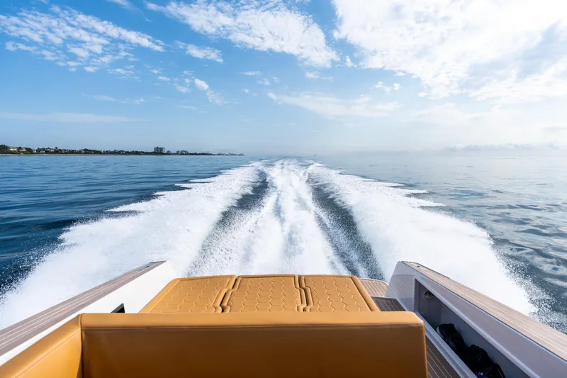 R01 Yacht Photos Pics 2023 VanDutch 32 yacht cruising on open water, leaving a wake under a clear blue sky.
