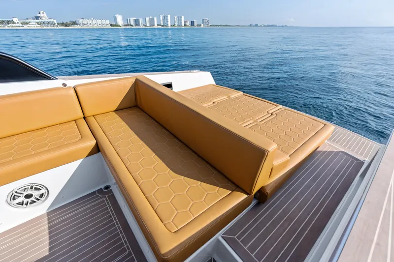 R01 Yacht Photos Pics Luxurious 2023 VanDutch 32 yacht with tan seating, ocean view, and city skyline in the background.