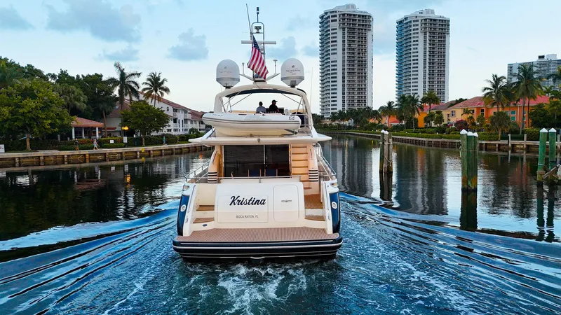 Kristina Yacht Photos Pics Luxury yacht "Kristina" cruising a canal, with high-rise buildings and palm trees in the background.