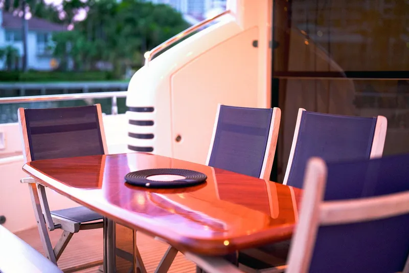 Kristina Yacht Photos Pics Outdoor dining area on a 2007 Princess 23M yacht with elegant wooden table and chairs.