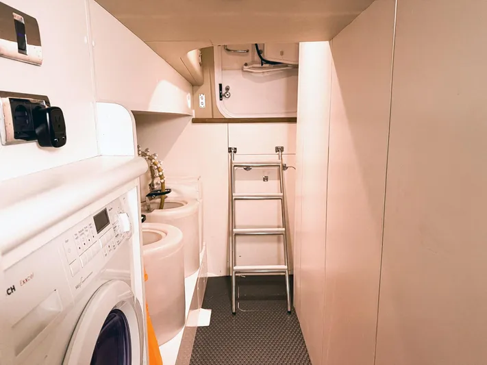Kristina Yacht Photos Pics Laundry area inside a 2007 Princess 23M yacht, featuring a washing machine and storage space.