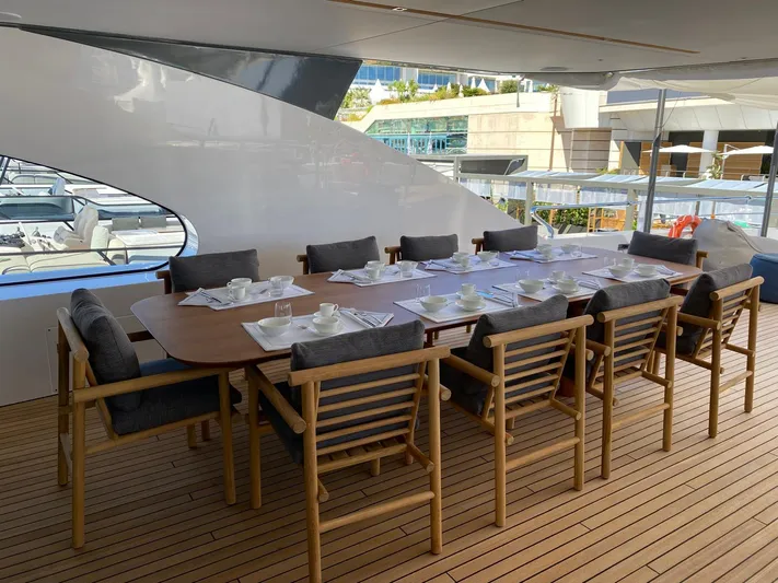  Yacht Photos Pics Outdoor dining area on 2024 Azimut Magellano 30M yacht with elegant wooden table and chairs.