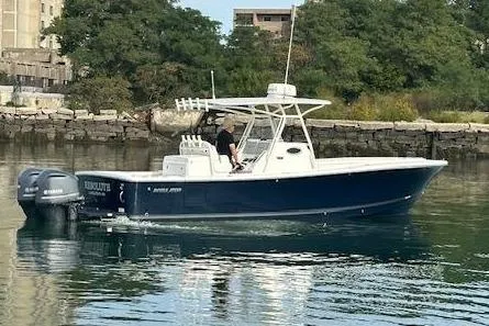 Resolute Yacht Photos Pics 2017 Regulator 31 boat on calm water near urban shoreline.