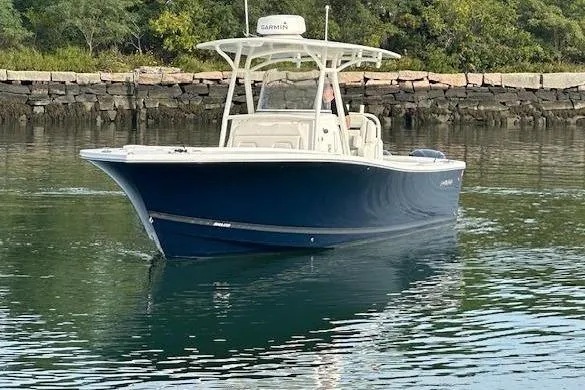 Resolute Yacht Photos Pics 2017 Regulator 31 boat on calm water near rocky shoreline.