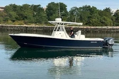 Resolute Yacht Photos Pics 2017 Regulator 31 boat on calm water with lush green shoreline.