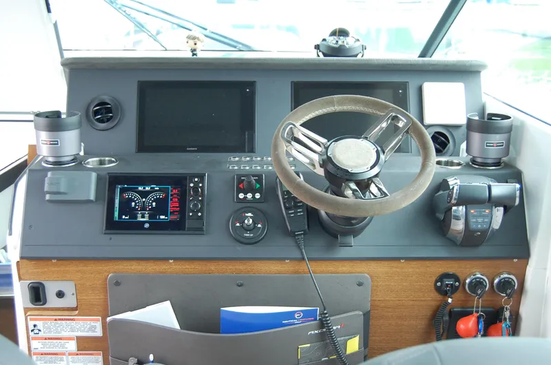  Yacht Photos Pics Control panel of a 2019 Axopar 37 SC boat with steering wheel and navigation displays.