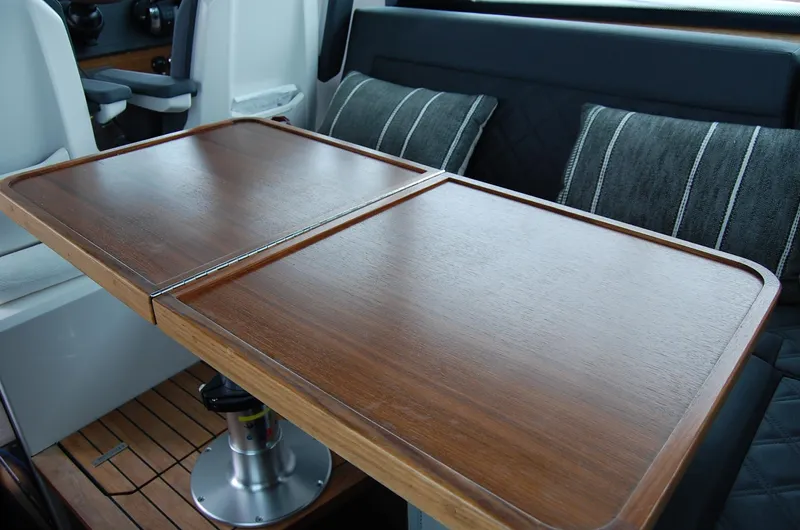  Yacht Photos Pics 2019 Axopar 37 SC interior with wooden table and cushioned seating.