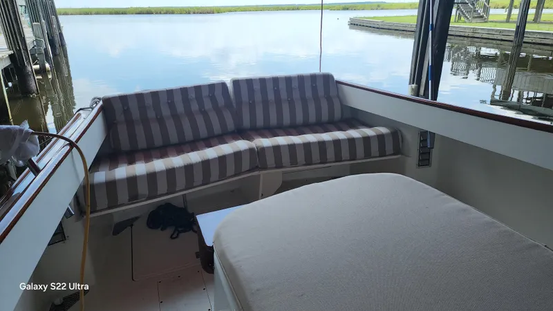 Stardust Yacht Photos Pics 1996 Hinckley Picnic Boat interior with striped seating, docked by calm water.
