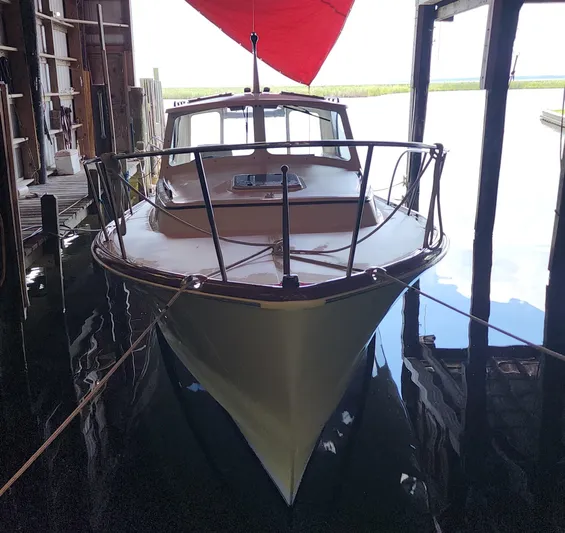 Stardust Yacht Photos Pics 1996 Hinckley Picnic Boat docked in a boathouse with red canopy.