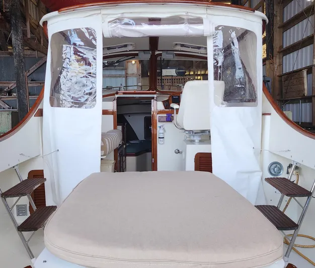 Stardust Yacht Photos Pics 1996 Hinckley Picnic Boat interior with seating and helm, docked in a wooden boathouse.