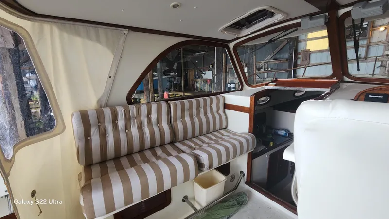 Stardust Yacht Photos Pics Interior of a 1996 Hinckley Picnic Boat with striped seating and wooden accents.