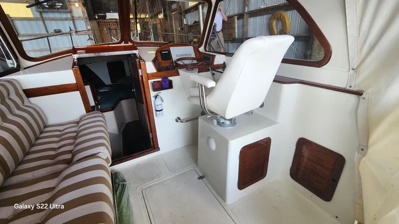 Stardust Yacht Photos Pics Interior of a 1996 Hinckley Picnic Boat with striped seating and navigation equipment.
