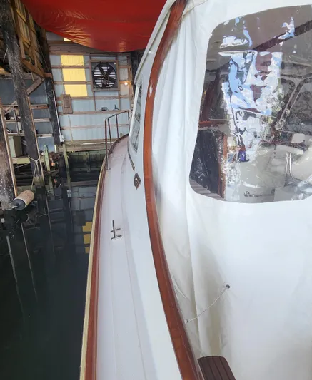 Stardust Yacht Photos Pics 1996 Hinckley Picnic Boat docked in a boathouse, side view with clear windows.