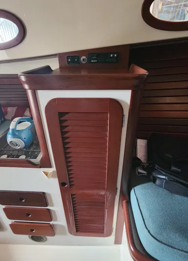 Stardust Yacht Photos Pics Interior of a 1996 Hinckley Picnic Boat with wooden cabinetry and a blue kettle.