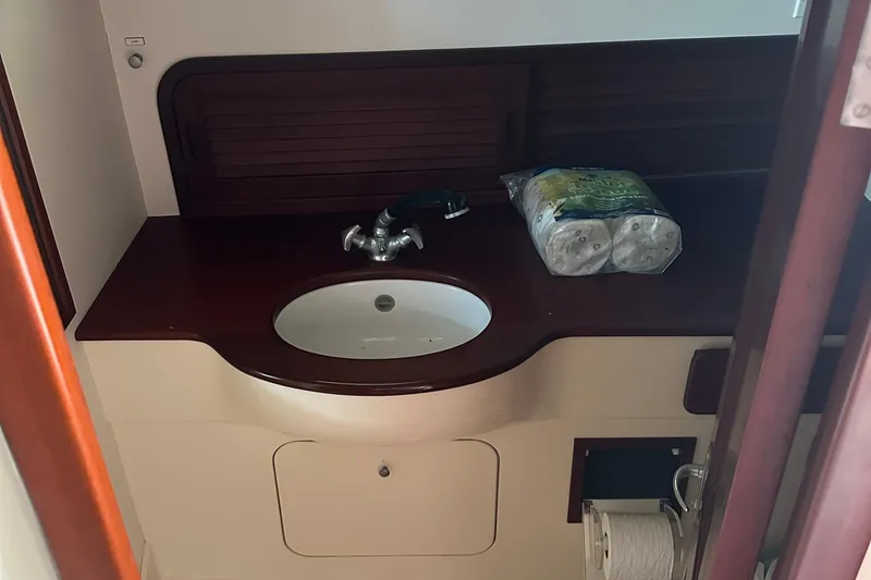 Stardust Yacht Photos Pics 1996 Hinckley Picnic Boat bathroom with sink, wooden counter, and toilet paper rolls.